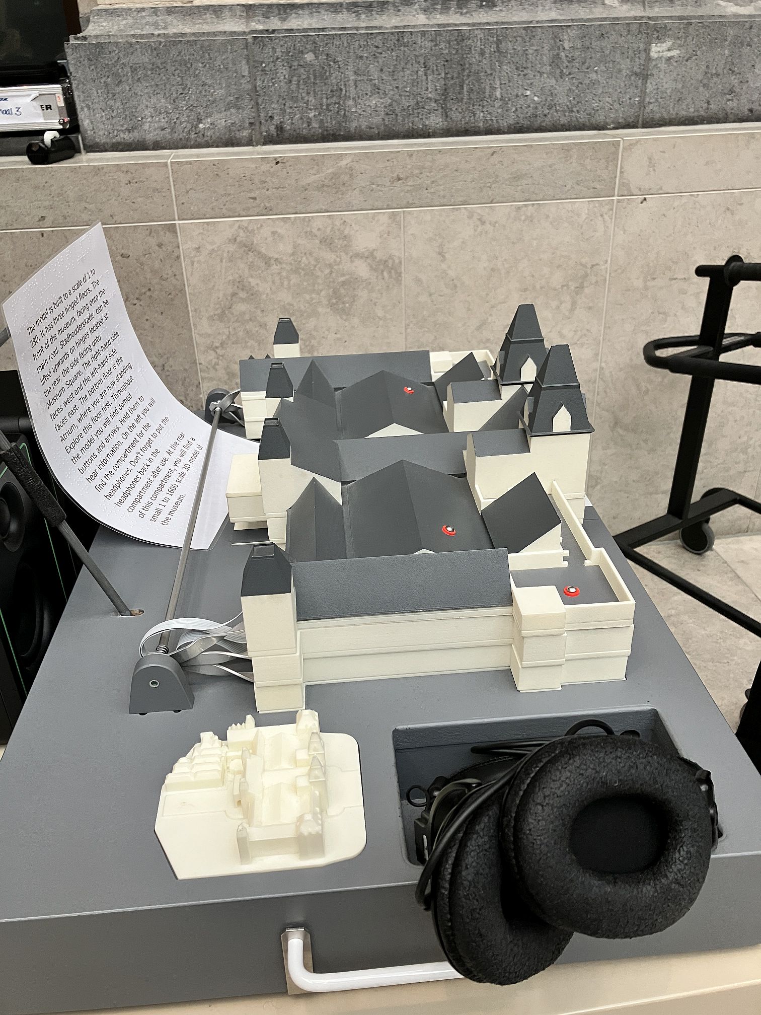 De audiomaquette van opzij met klein 3D-model en koptelefoon