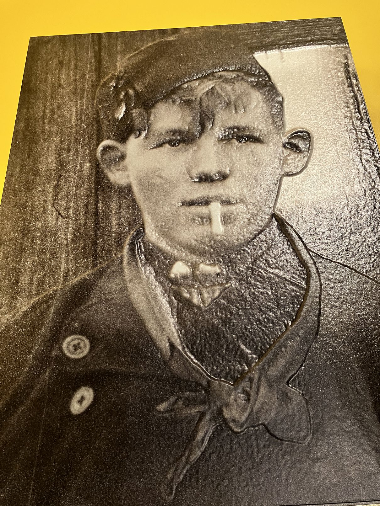 Reliëffoto jongeman in klederdracht met sigaret uit 1938